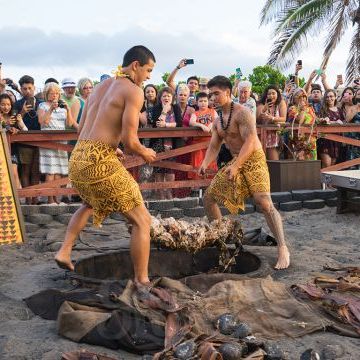 a person standing in front of a crowd of people at a beach